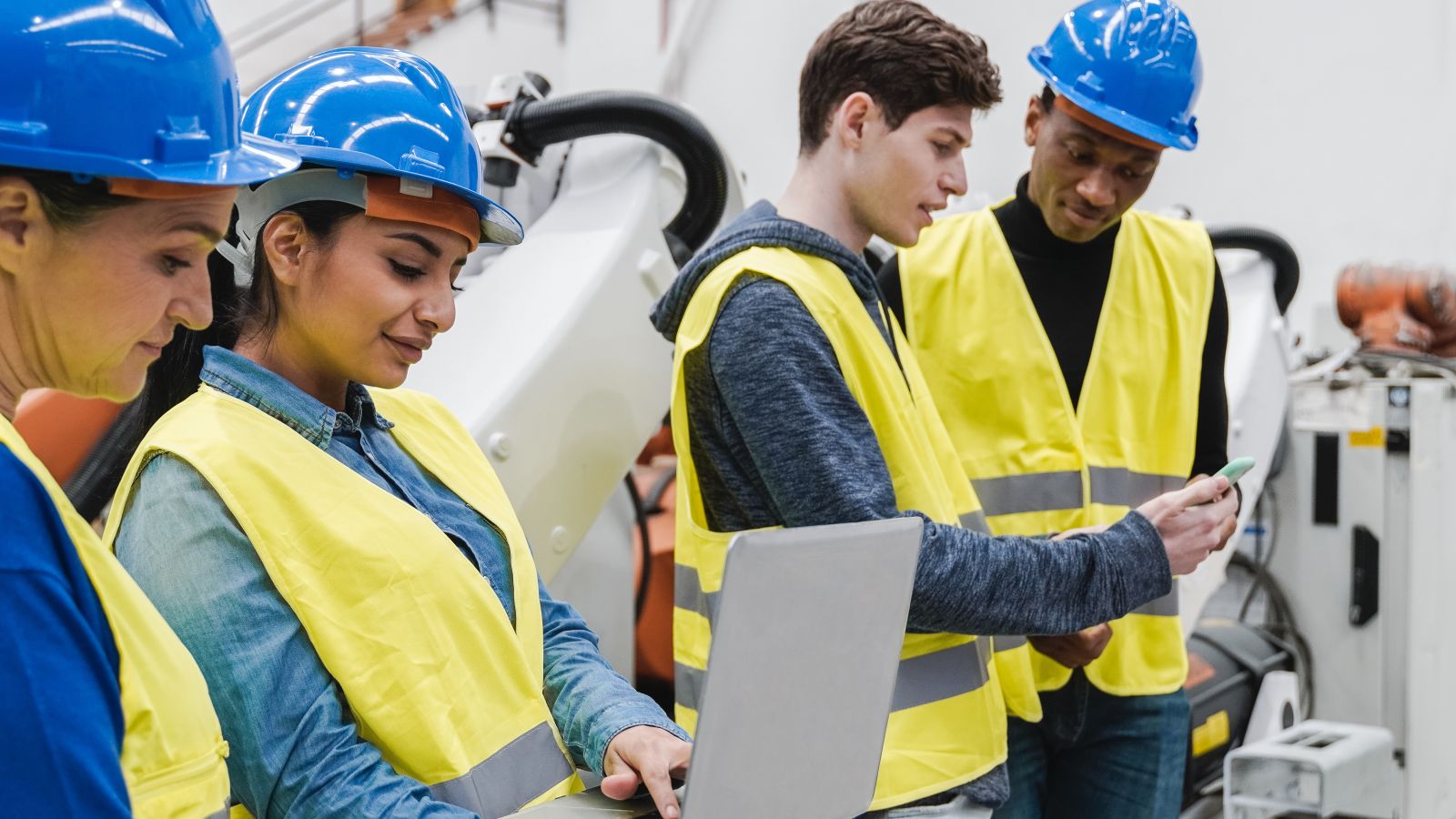 Vier Ingenieur*innen in automatisierter Fabrik. 